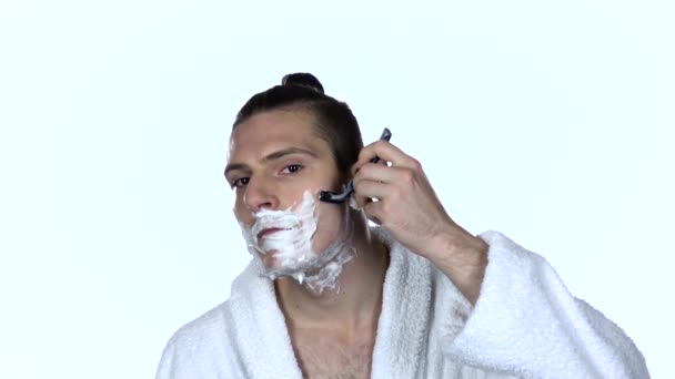 Male shaves face with blade razor. White background. Slow motion — Stock Video