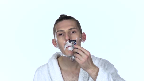 Мужчина бреет лицо под носом. Белый фон. Медленное движение — стоковое видео