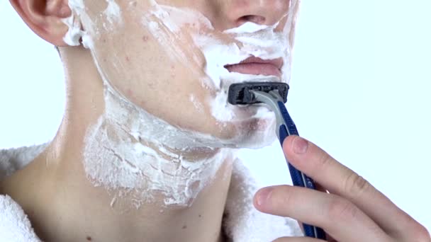 男はゆっくりとあごの使い捨てカミソリを剃る。スローモーション。クローズ アップ — ストック動画