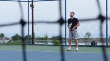 Tenis konsepti. Oyuncu kortta tenis topu bekliyor, önünde net