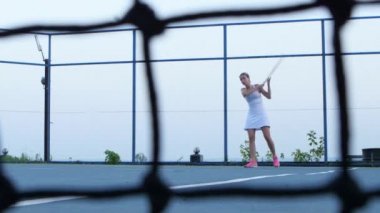 Tenisçi forehand tekniğini kullanarak vole. Tenis ağı önde. Açık hava kortları