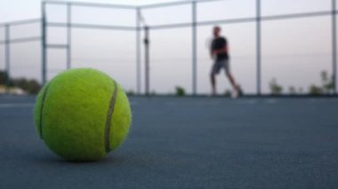 Sahada tenis topu. İnsanlar açık havada Tenis oynuyorlar