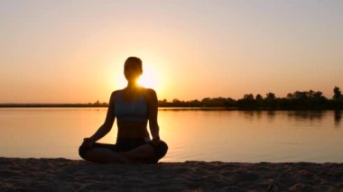 Kadın poz lotus turuncu güneş üzerinde meditasyon