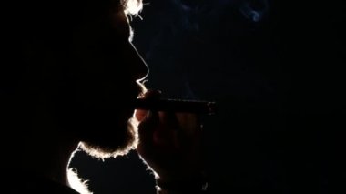 Adam puro içiyor. Siyah. Siluet. Yakın çekim