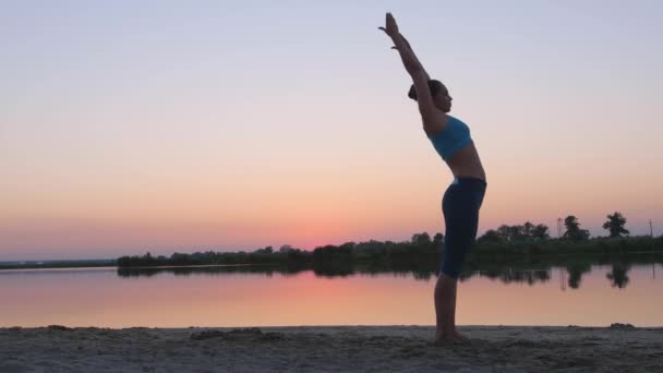 Menina ao pôr do sol mostrando exercícios de ginástica — Vídeo de Stock