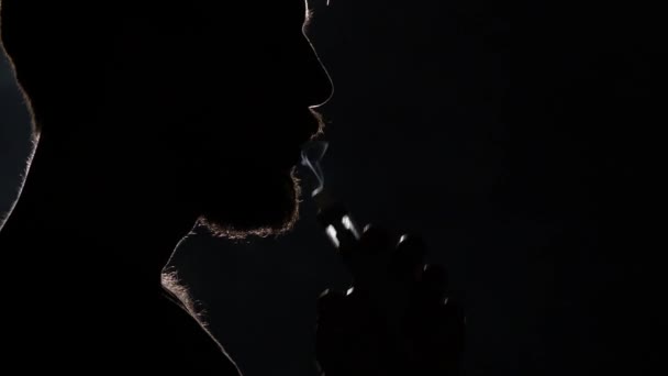 Hombre fumando cigarrillo electrónico en negro. Silueta. De cerca. — Vídeos de Stock