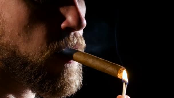 Mannen i ett mörkt rum, röka en cigarr. På nära håll — Stockvideo