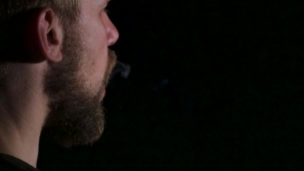 Vidéo comme un homme fume un gros cigare. Noir. Gros plan — Video