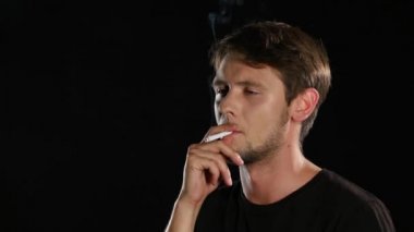 Adam karanlık bir odada bir sigara içiyor. Siyah. Yakın çekim