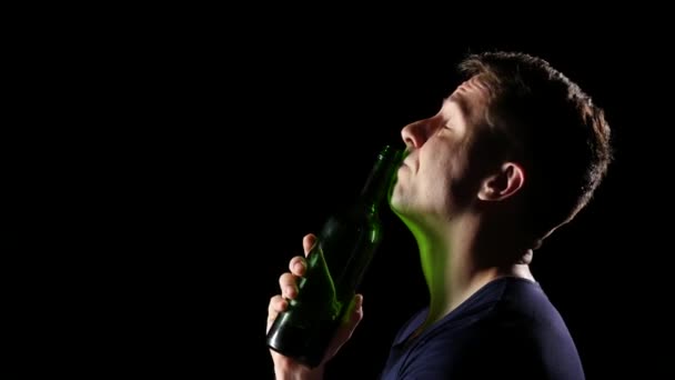 Sorgliga ung man dricker vin med en hals. Svart. På nära håll — Stockvideo