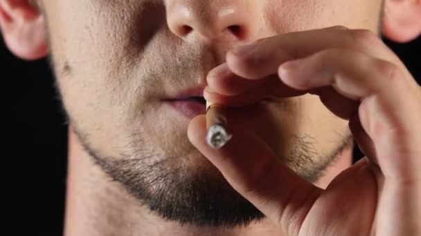 Ο άνθρωπος καπνίζει ένα τσιγάρο. Κακές συνήθειες. Μαύρο. Κοντινό πλάνο — Αρχείο Βίντεο