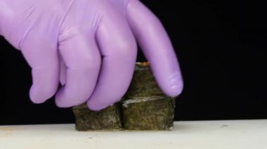 Suşi ustası ruloları sütunlara koyar. Yakın çekim