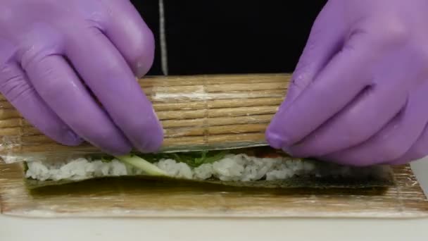 Chef utilise un tapis de bambou pour préparer des sushis. Gros plan — Video