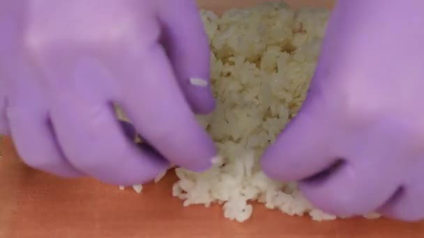 Cook pone arroz blanco en la sábana rosa nori. De cerca. — Vídeos de Stock