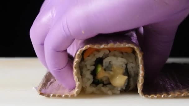 Sushi-Chef decoreert roll en bereidt het voor om te serveren. Close-up — Stockvideo