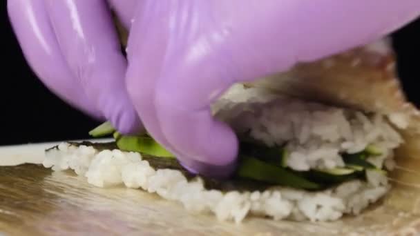 Chef prepares a roll with avocado and cucumber for filing. Close up — Stock Video