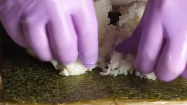 Chef met du riz blanc sur la feuille de nori. Gros plan 