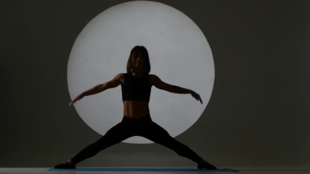 Athlete sits on side splits. Back light. Silhouette — Stock Video