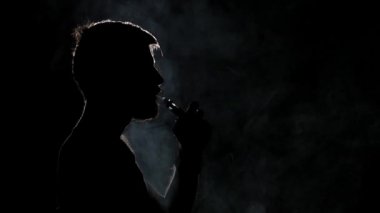 Kötü alışkanlıklar. Elektronik Sigara. Siyah. Siluet. Yakından kapatın. Yavaş çekim