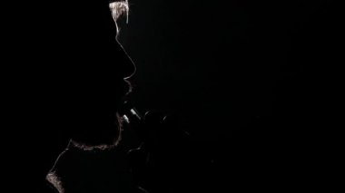 Adam ağzından duman halkaları izin verdi. Siyah. Siluet. Yavaş çekim