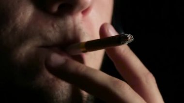 Karanlık bir odada sigara içiyor. Siyah. Yakından kapatın. Yavaş çekim