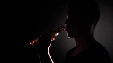 Şişeden bira içen adam. Gri. Yakından kapatın. Yavaş çekim