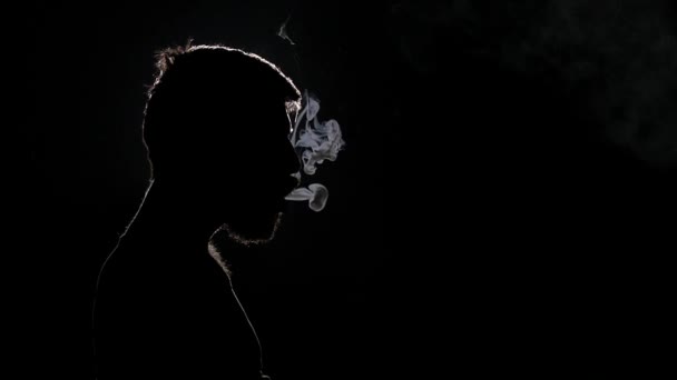 Sigaretta elettronica. Quell'uomo ha lasciato squillare il fumo dalla sua bocca. Nero. Silhouette. Rallentatore — Video Stock