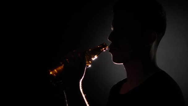 Man dricker öl från en flaska. Grå. Närbild. Slow motion — Stockvideo
