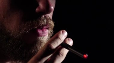 Sakallı, elektronik sigara içen bir adam. Siyah. Yakından kapatın. Yavaş çekim