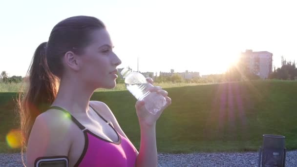 Женщина пьет воду после пробежки. Медленное движение — стоковое видео