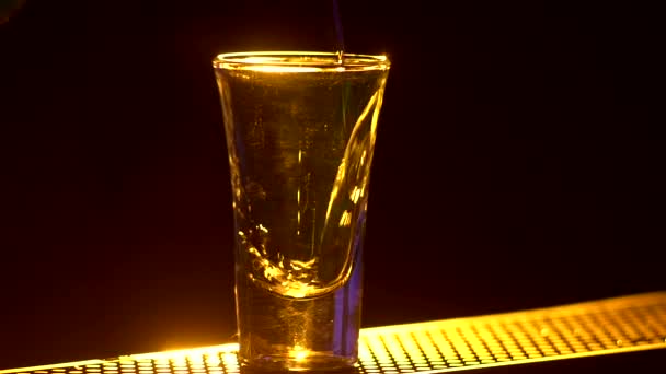 Бармен делает коктейль и на краю барной стойки, выстрелы, закрыть, задний свет, замедленная съемка — стоковое видео