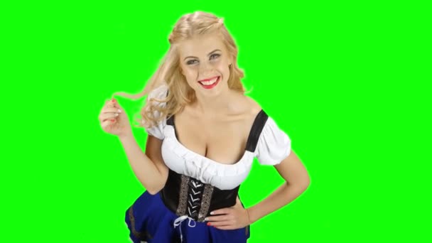 Баварская женщина флиртует, чтобы пощупать прядь волос и улыбнуться. Зеленый экран — стоковое видео
