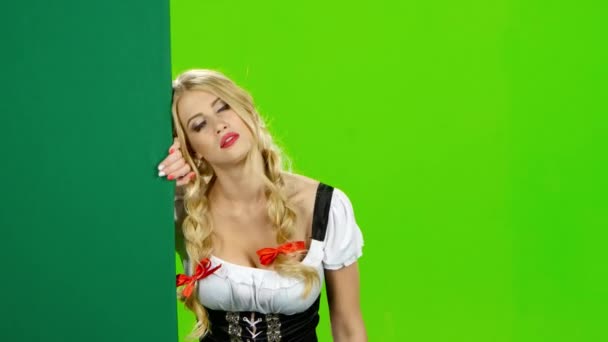 Девушка в баварском костюме манит ей рукой и машет ей на прощание. Зеленый экран — стоковое видео