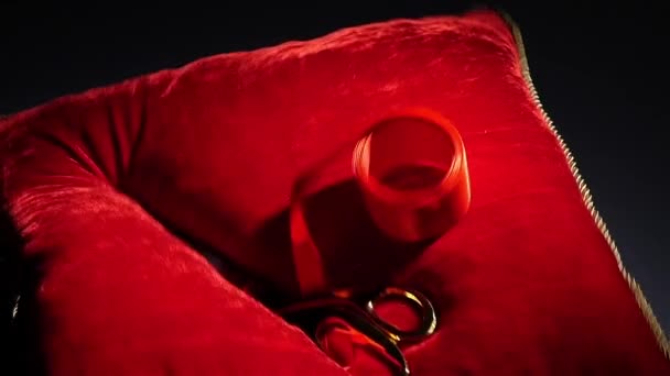 Золоті ножиці падають на червону подушку — стокове відео