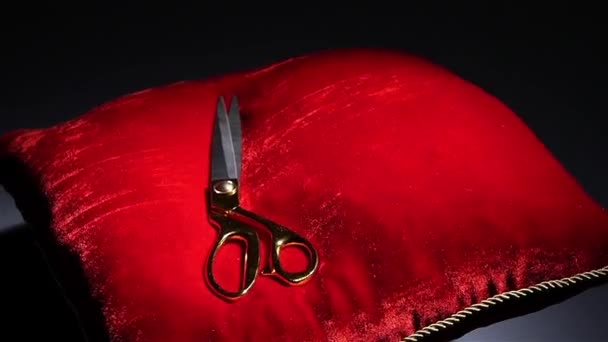 Золоті ножиці падають на червону подушку — стокове відео