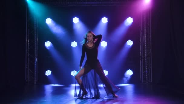 Impulsiv dansende utøver i en samtidig stil av kontemp koreografi på svart bakgrunn med blått lys. Langsom bevegelse. – stockvideo