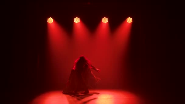 Jonge elegante vrouwelijke danser in zwart kostuum die contemp choreografie uitvoert in de rook van een dansstudio. Silhouet. Langzame beweging. — Stockvideo