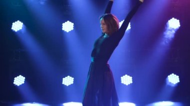 Nazik, esnek dansçı, mavi spot ışıkları önünde çağdaş tefekkür koreografisinin akrobatik unsurlarını sergiler. Kapatın. Yavaş çekim.