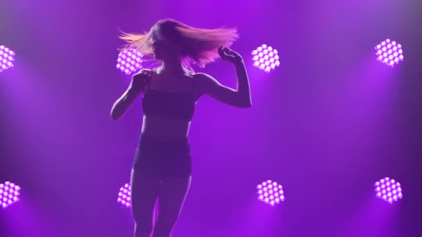 Delicate hedendaagse choreografie van minachting uitgevoerd door een professionele danseres tegen een achtergrond van rook en licht. Silhouet van een slanke vrouw van dichtbij. Langzame beweging. — Stockvideo