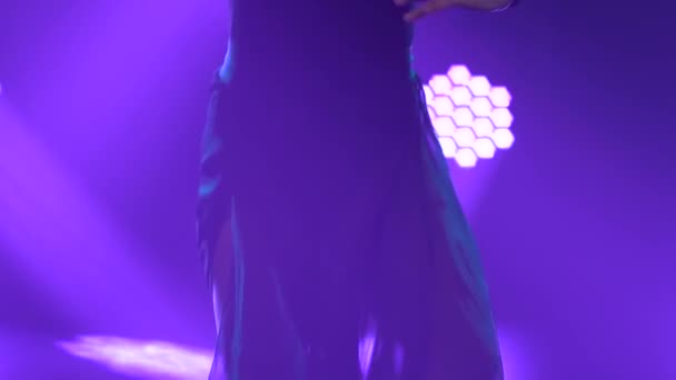 Happy female danser treedt op in moderne contemp choreografiestijl op een zwarte achtergrond met paarse lichtjes. Langzame beweging close-up. — Stockvideo