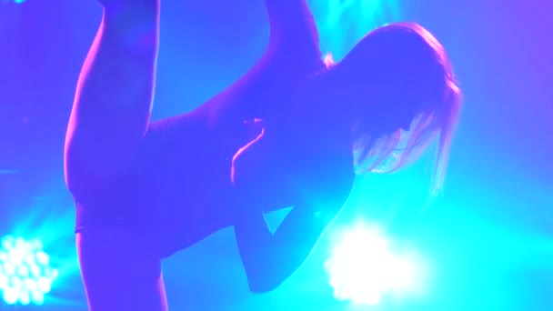 Силуэт туловища изящной танцовщицы в чёрном костюме, исполняющей серию танцевальных движений и акробатических элементов во время современного созерцания исполнения в луче синего света. Медленное движение.. — стоковое видео