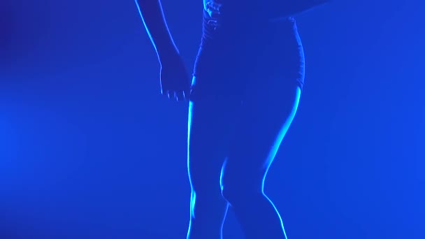Sensual coreografía contemporánea de desprecio realizada por un bailarín profesional con un telón de fondo de humo y luz azul. La silueta de una mujer delgada, las piernas se cierran. Movimiento lento. — Vídeo de stock