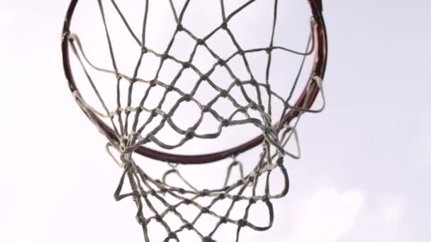 Les balles de basket-ball tombent à travers le cerceau vers la caméra et frappent l'anneau. Vue du bas. Ferme là. Mouvement lent. — Video