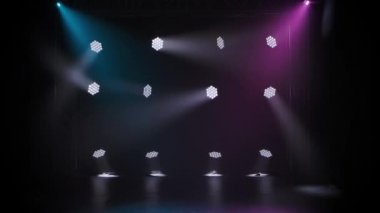 Konser ışıkları. Geceleri tiyatro sahnesinde ışık efektleri. Sirk arenasında sahne ışıkları parlıyor. Çok renkli kirişli ışıklandırma ekipmanı.