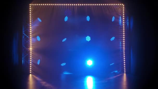 Podiumlicht in een lege concertzaal. Professionele verlichting en show effecten. Blauwe dynamische spots en spot gele verlichting schijnen tegen een zwarte achtergrond. — Stockvideo