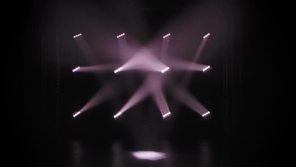 Projecteurs blancs mobiles et clignotants sur fond noir scène vide. Des néons clignotent lors d'une fête disco, d'un mariage ou d'un anniversaire, ou lors d'une discothèque. Équipement d'éclairage. — Video