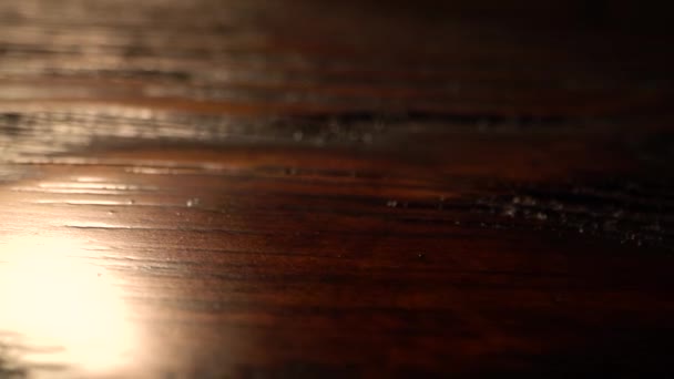 Macro flat wooden surface tracking. Vertical sliding camera moving along a brown textured table with a shiny lacquered surface. Wood texture. Dolly shot. — Stock Video