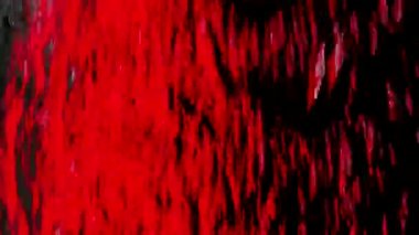 Su akıntısı, siyah arka planda yavaş çekimde cam pencereye düşer. Suyun akıntıları stüdyo kırmızı ışıkla aydınlatılır. Su jetleri kapanıyor..