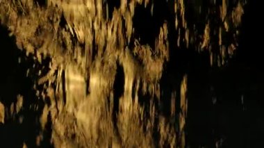 Su akıntısı, siyah arka planda yavaş çekimde cam pencereye düşer. Suyun akıntıları stüdyo sarı ışıkla aydınlatılır. Su jetleri kapanıyor..