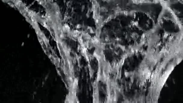 Objekt padající do vody shora a stříkající kapky tekutiny na černé pozadí. Vodní bublina praskající proti s mnoha stříkanců ve zpomaleném filmu zblízka. — Stock video